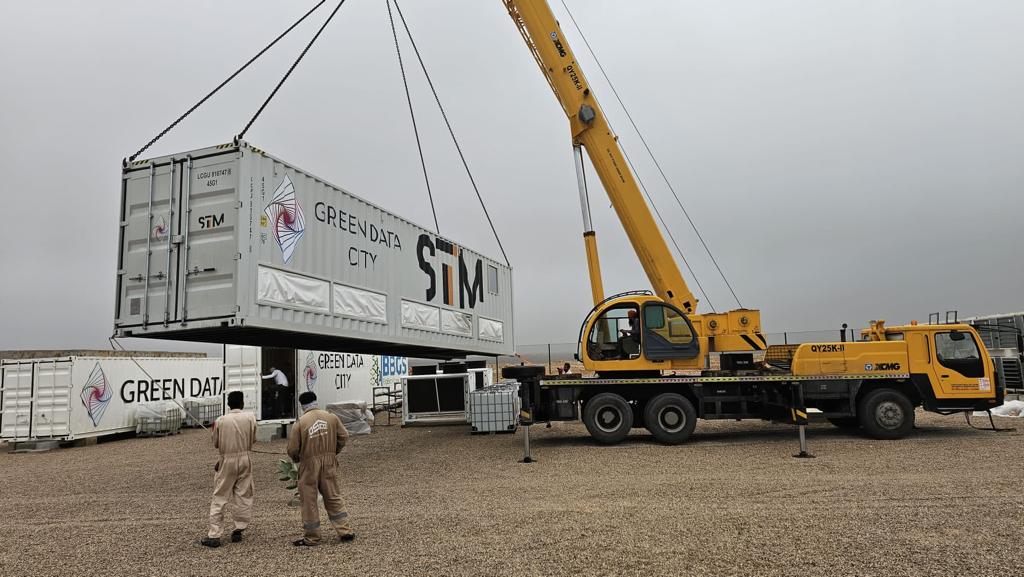 XCMG crane lifting an STM branded mining container at the Green Data City installation site